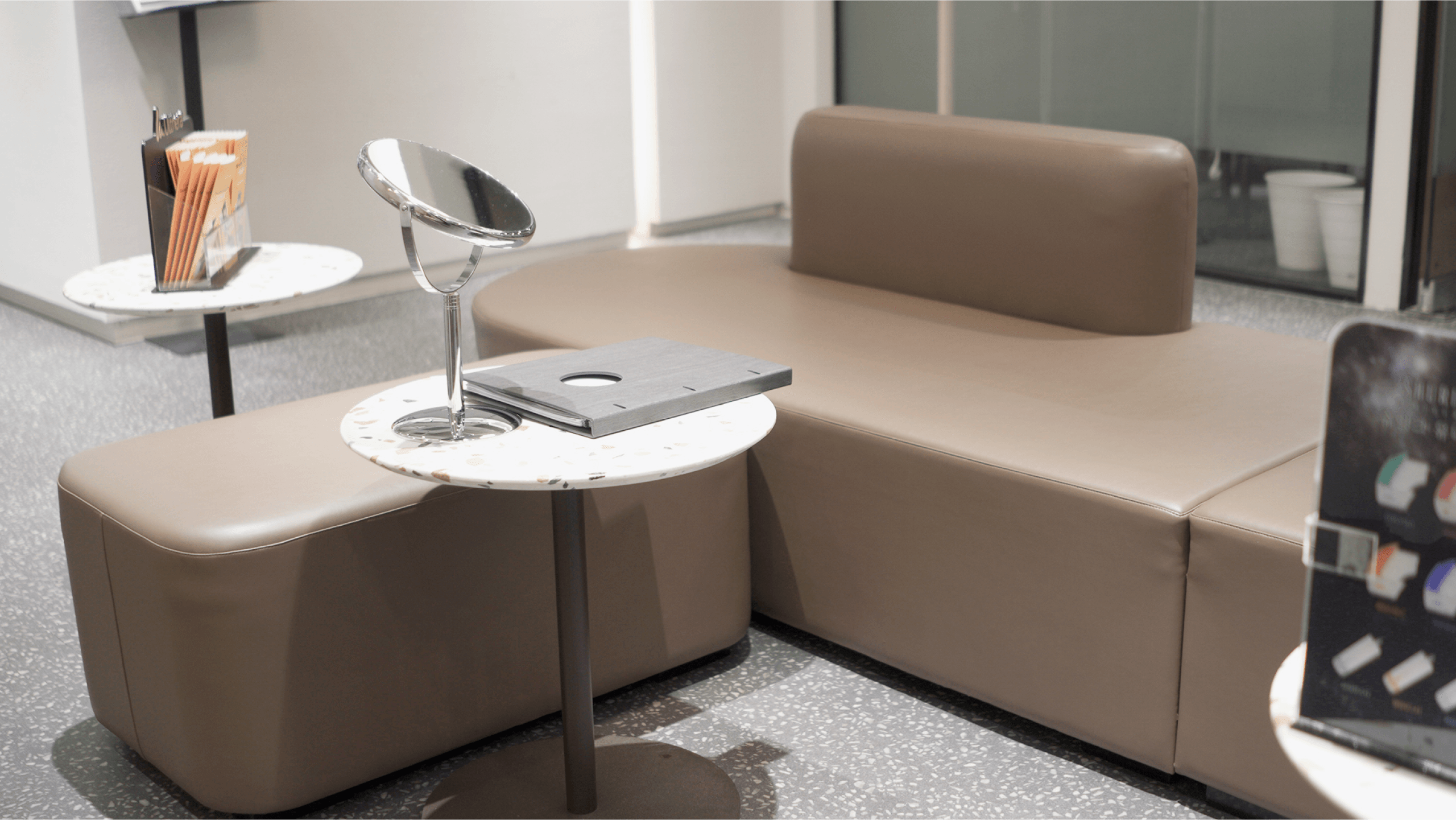 思麗本 S Reborn 弘大店等候區，棕色弧形沙發、桌上放有化妝鏡，環境溫馨舒適