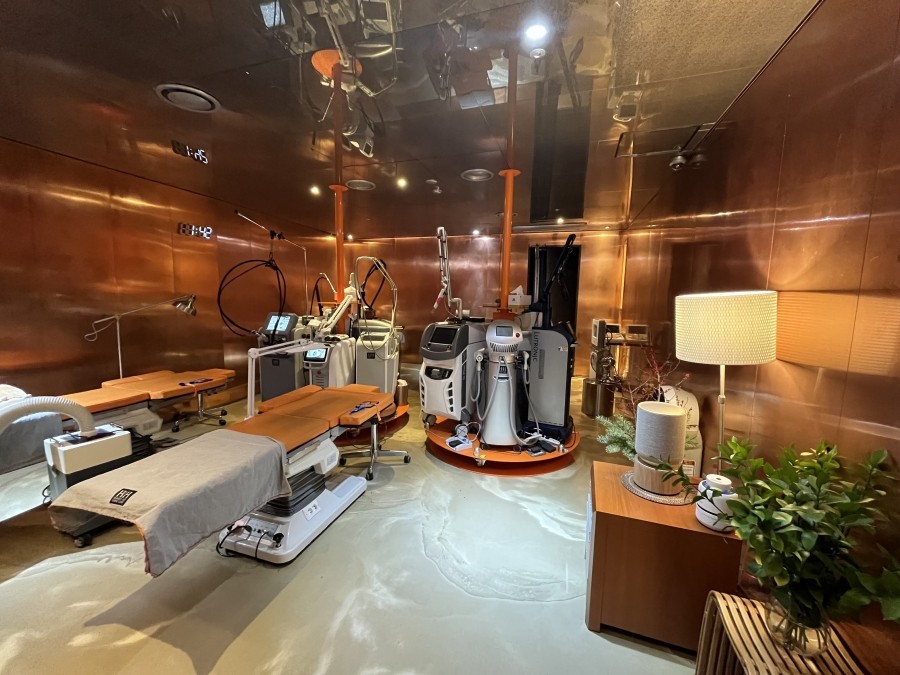 ヘヒ皮膚科レーザー機器室 – 銅色の金属壁に専用機器が多数設置されている